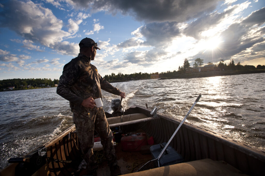 Homme dans un bâteau s'en allant èa la pêche dans la zec du lac Kipawa. 